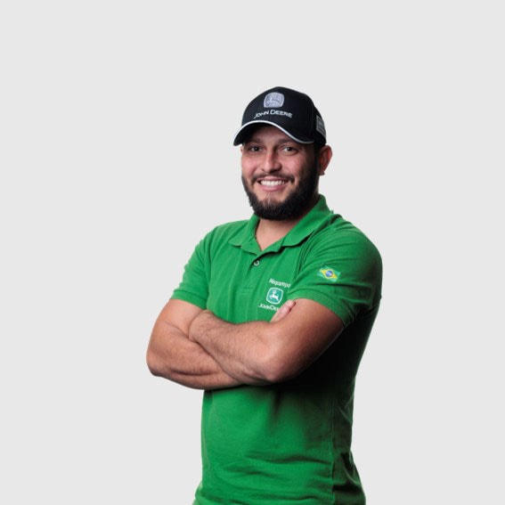 Lucas Lustrosa com braços cruzados vestindo um boné preto e uma camisa verde.