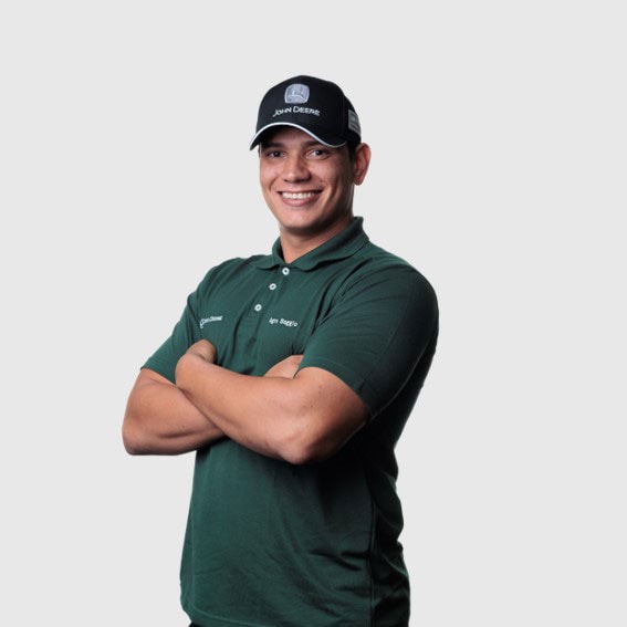 Lucas Souza com braços cruzados vestindo um boné preto e uma camisa verde.