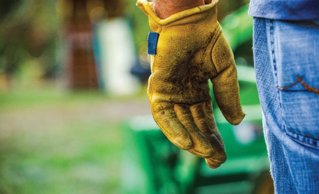 close up of a person's work glove and jeans