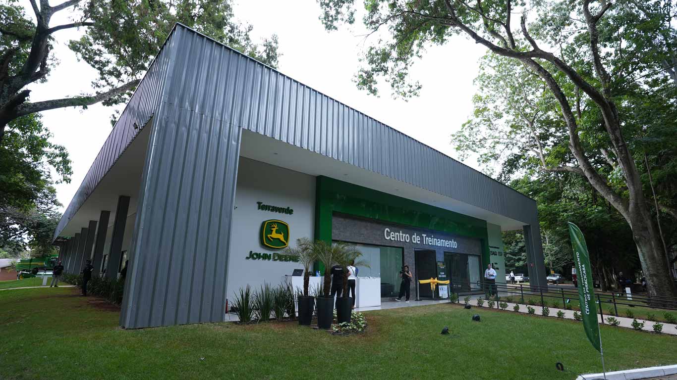 A new John Deere Training Center building with a modern design, surrounded by trees and greenery.