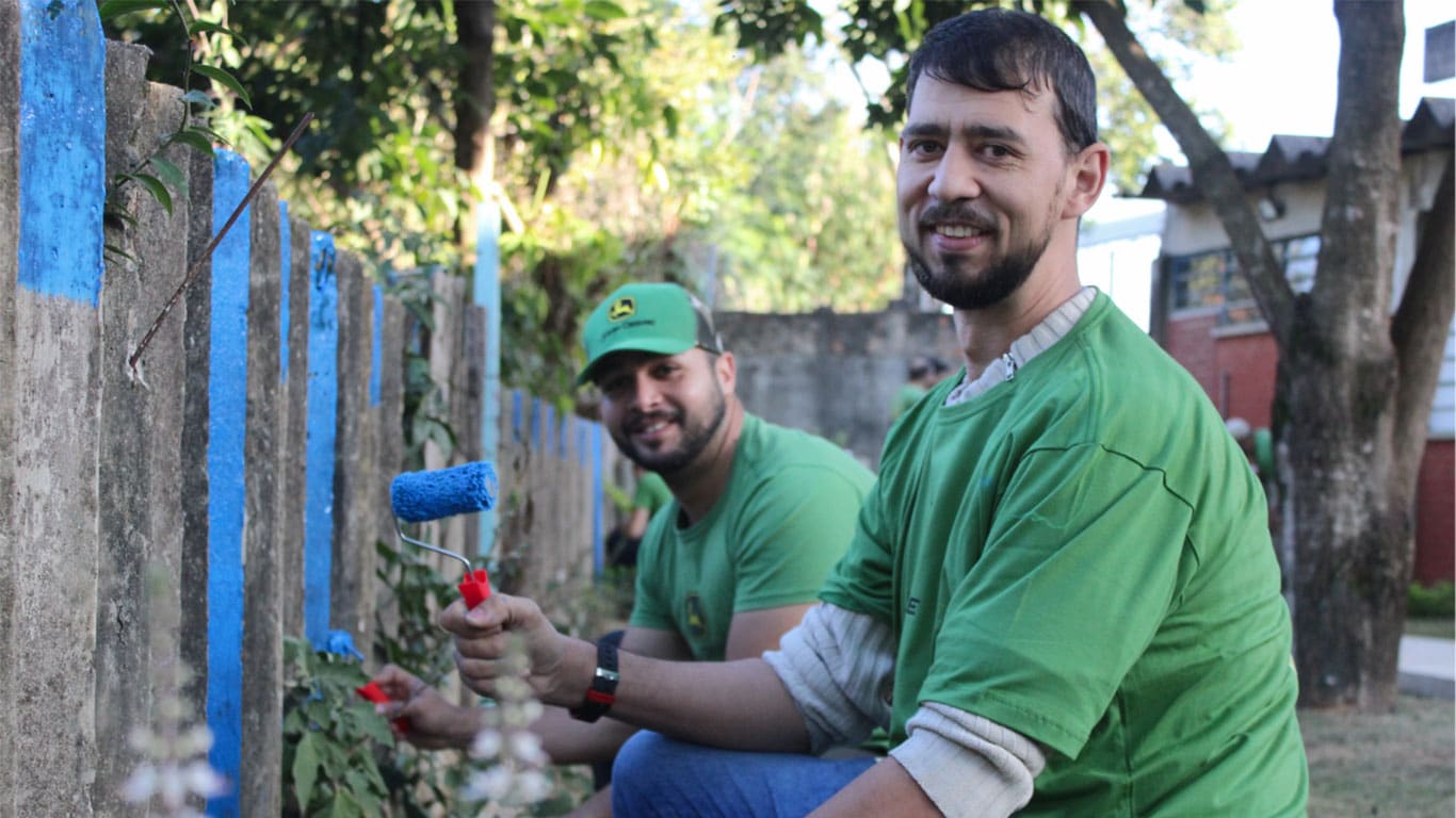 Dois voluntários John Deere em ação de pintura em escola