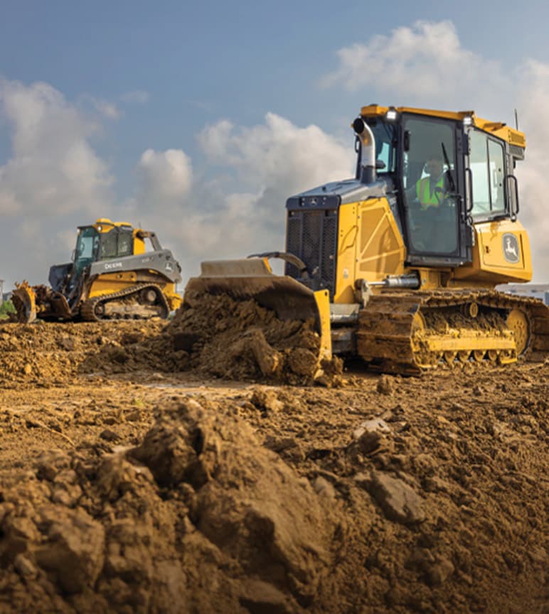 Dois veículos de construção, uma escavadeira e uma pá-carregadeira, movendo sujeira em um canteiro de obras.