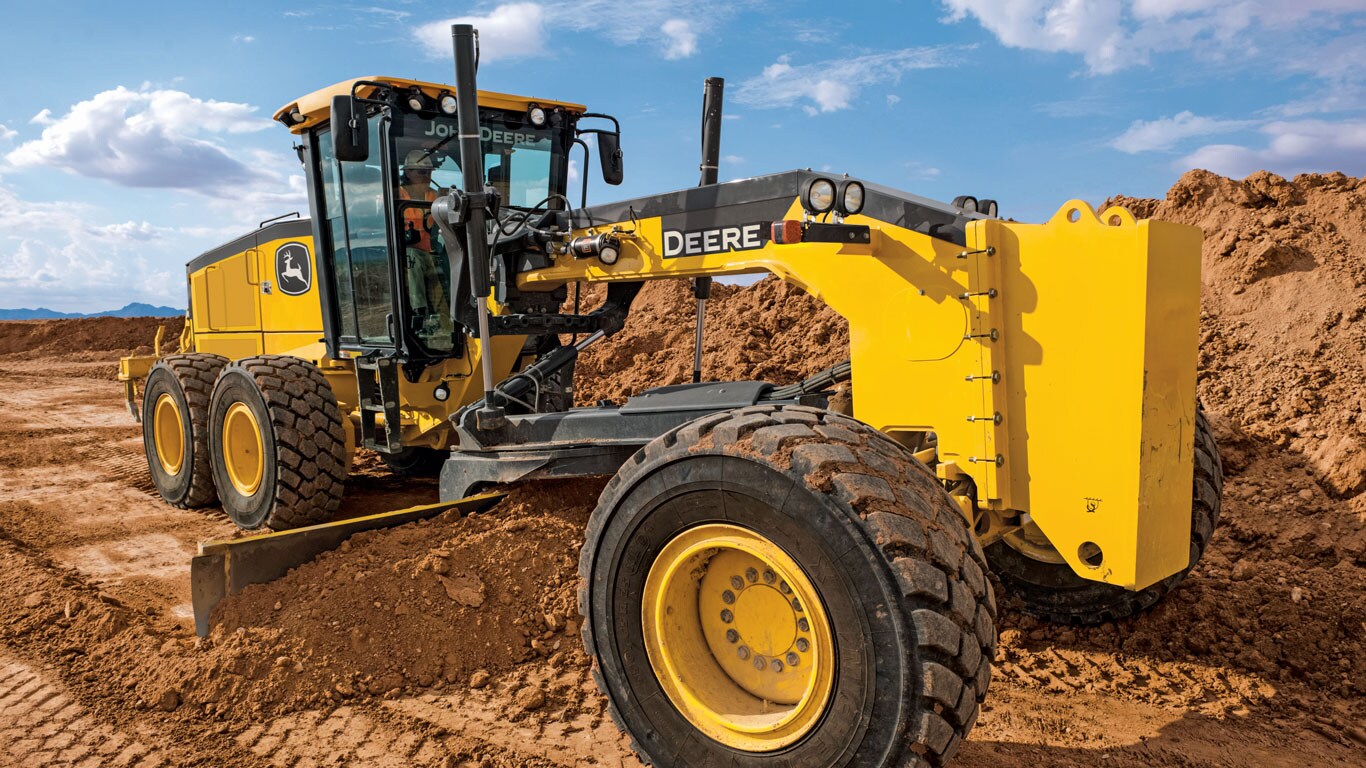 A motoniveladora John Deere nivela a terra em um canteiro de obras