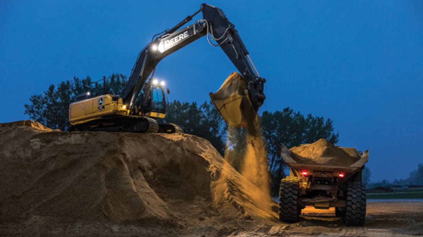 Equipamento de construção John Deere erguendo terra