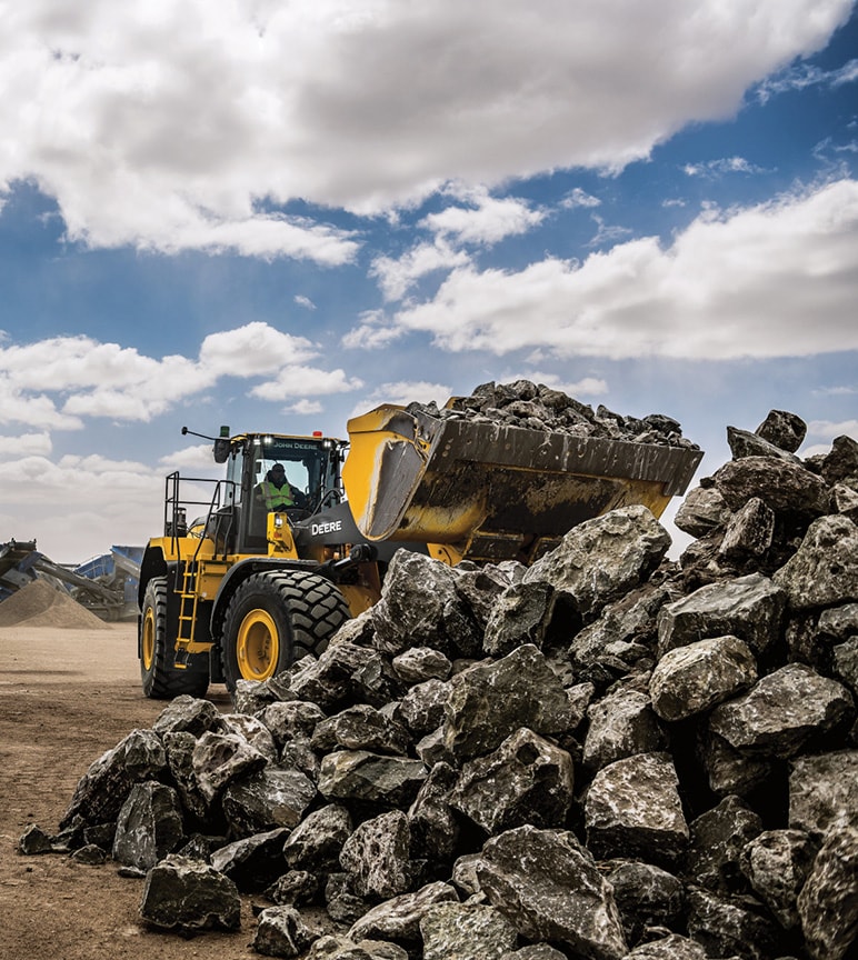 Equipamento de construção da Deere empilhando pedras
