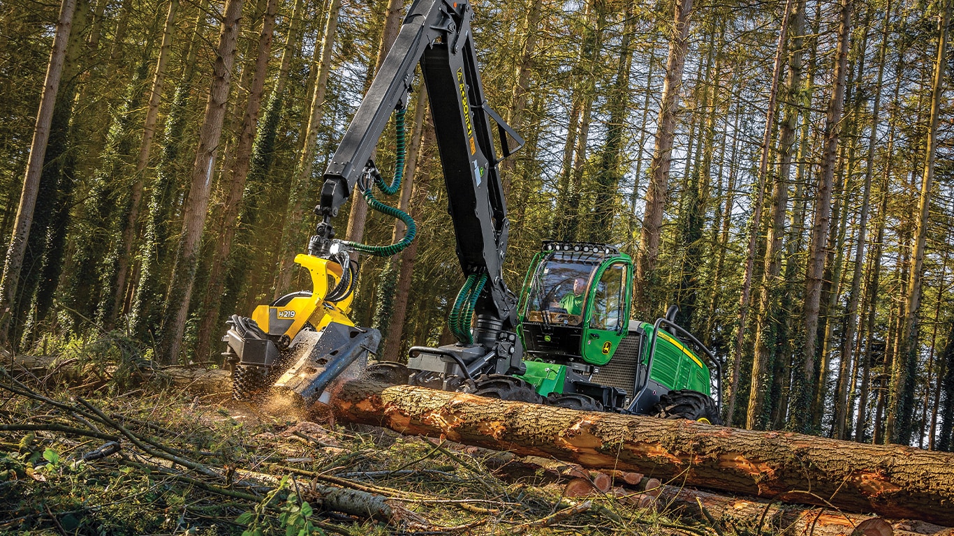 Harvester de pneus 1470G cortando um tronco de árvore em uma floresta.