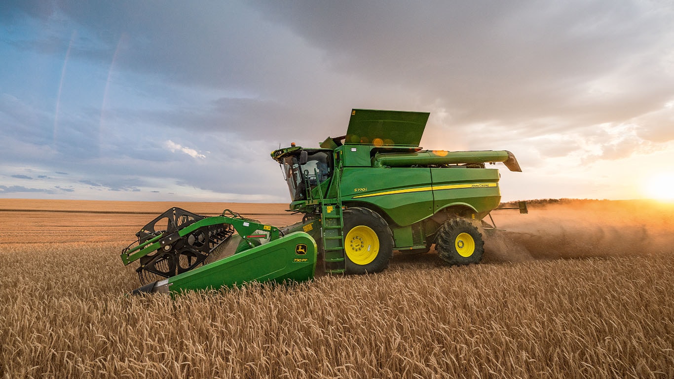 Colheitadeira John Deere em campo de trigo.