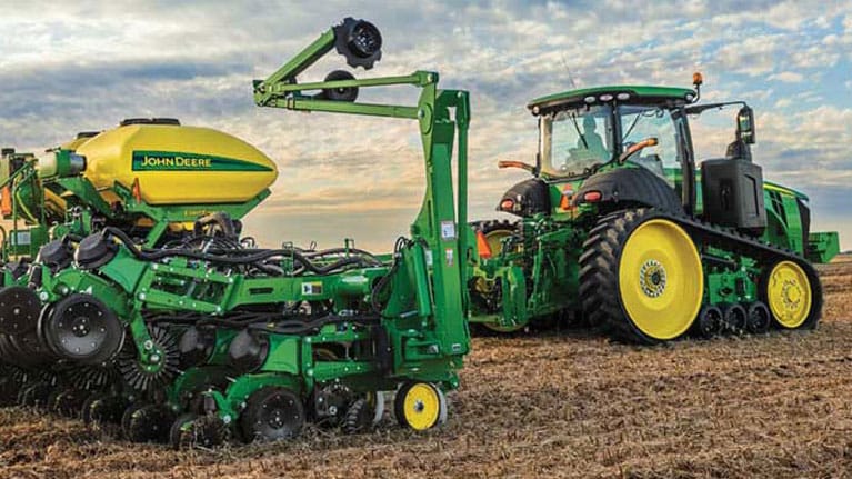 Equipamento de cultivo e trator John Deere em um campo