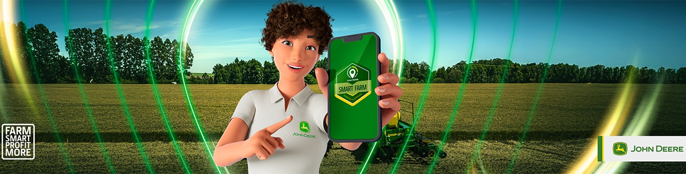 Ana com um telefone celular na frente de um campo com o sinal de Mais Lucro Inteligente da Fazenda e o logotipo da John Deere à direita