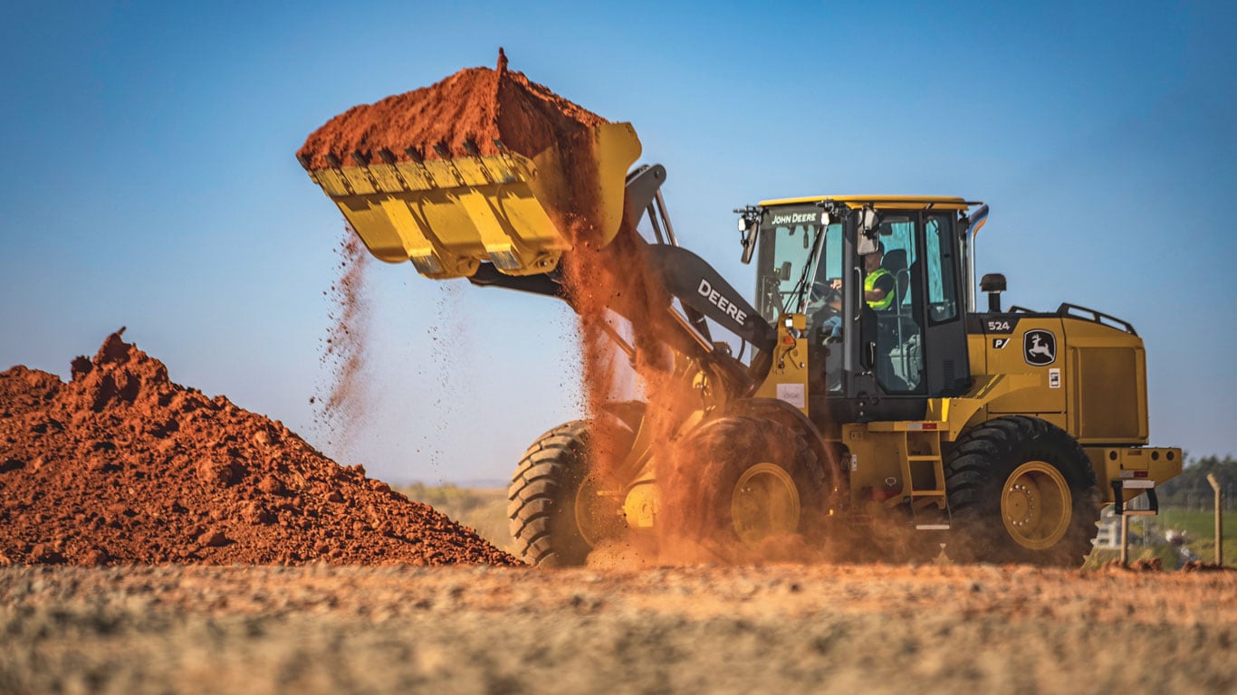 Carregadeira de rodas 524 P-Tier que usa caçamba para coletar e mover sujeira no canteiro de obras.