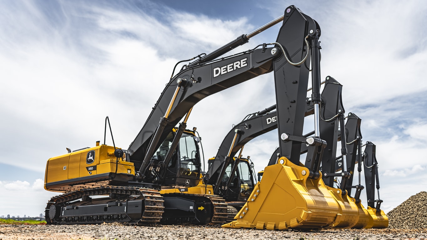 fila de quatro escavadeiras Deere de médio porte diferentes em cascalho