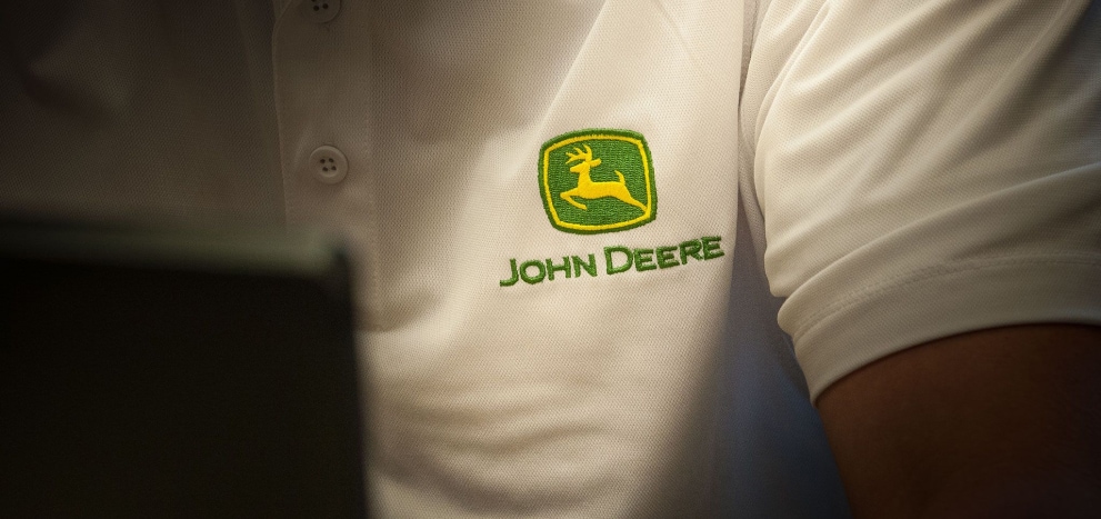 Silhueta do peitoral de uma pessoa utilizando uma camiseta branca com o logo da John Deere