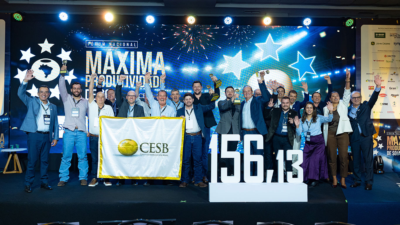 Foto de premiação em um palco de evento corporativo.
