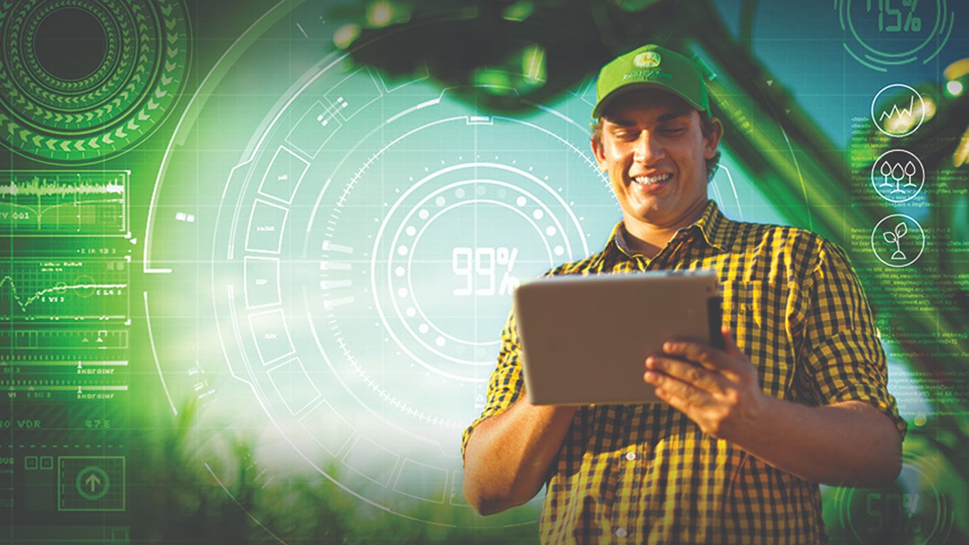 Pessoa usando um tablet em uma lavoura, com análises de agricultura digital e sobreposições de dados.