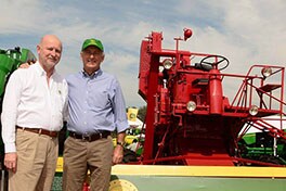 Paulo Herrmann e Eduardo Logemann posam em frente da 65A no estande da John Deere. (Foto: Carina Herrera)
