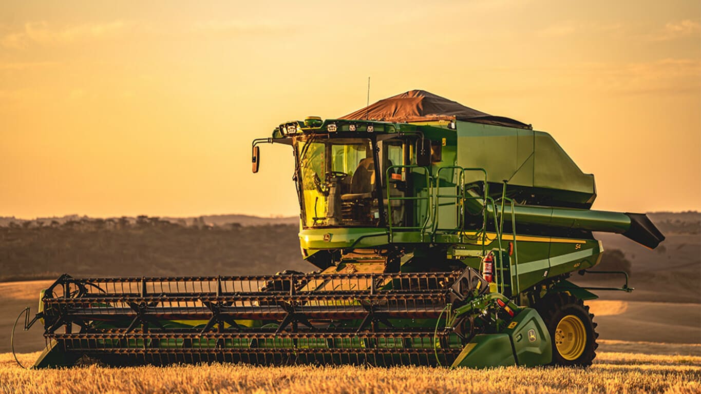 Colheitadeira S4 300 no campo ao entardecer.