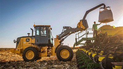 Pá carregadeira 444g com plantadeira no campo