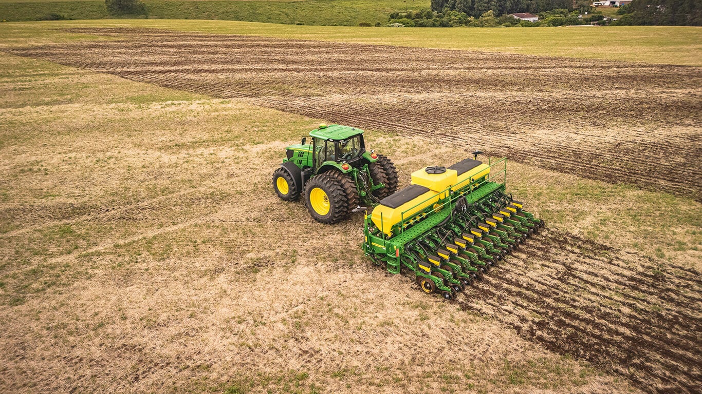 Máquina John Deere série 1200 no campo.