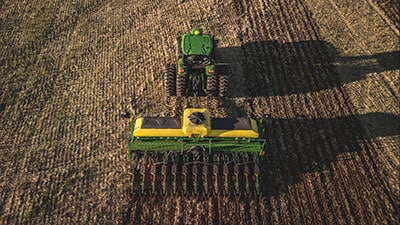 Máquina John Deere série 1200 no campo vista de cima.