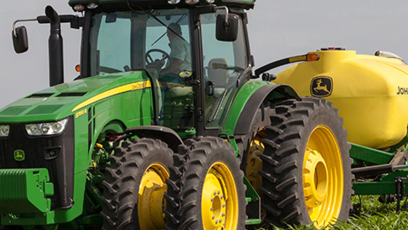 Trator John Deere com tanque de insumos no campo