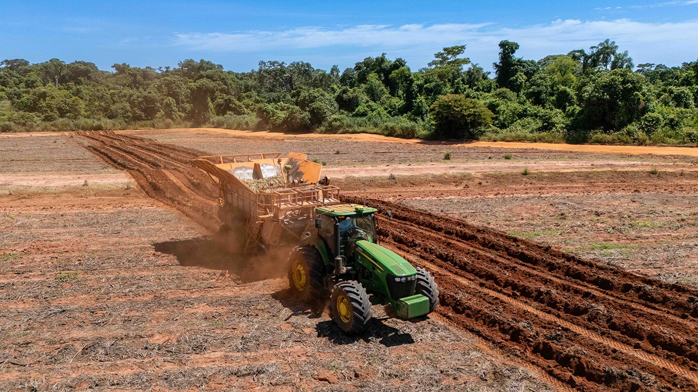 Trator com plantadeira de cana de açucar visto de cima diagonalmente, realizando o plantio utilizando autopath e ATIG.