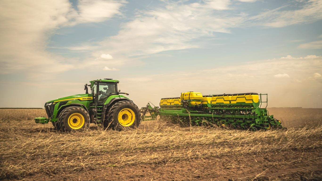 Trator 8R John Deere no campo.