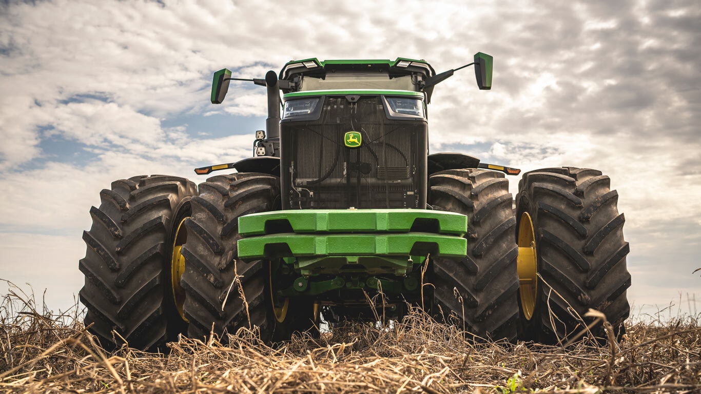 Trator 8R440 visto de frente no campo.